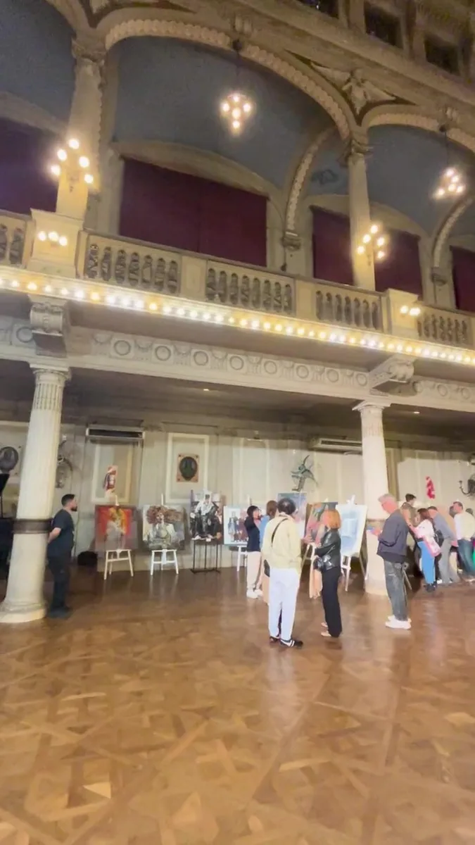Walk through the Colegio San José auditorium with the works on easels
