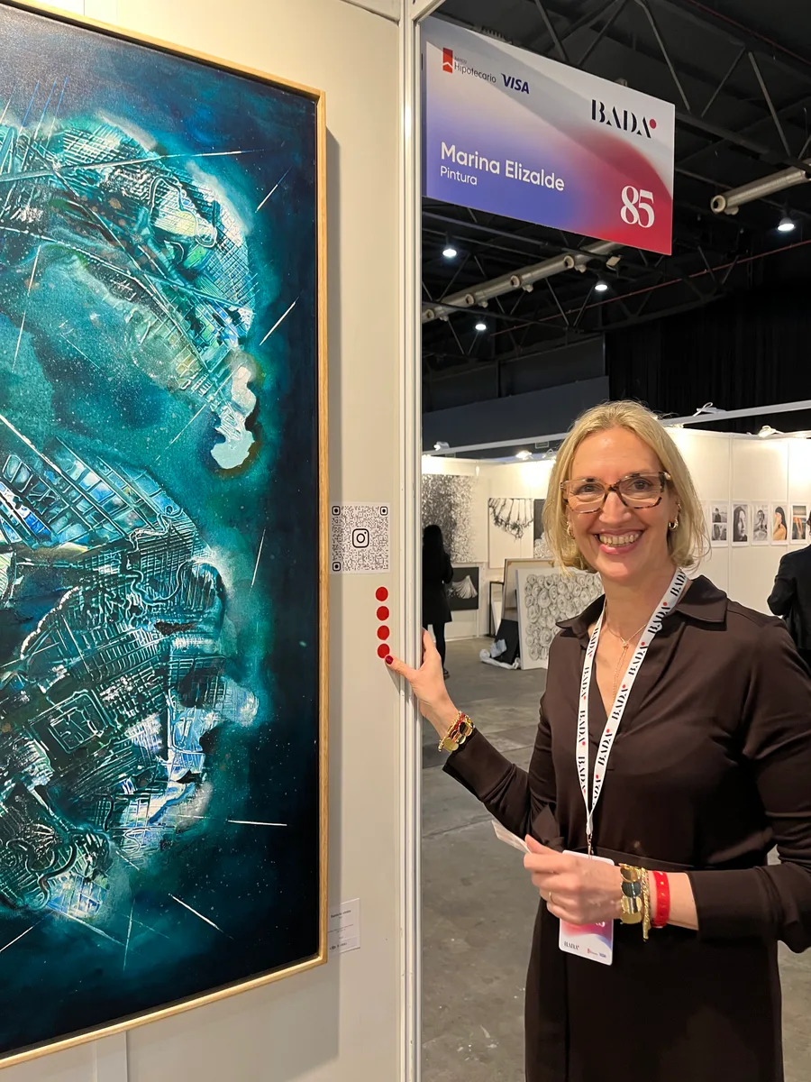 Marina Elizalde next to a large blue painting