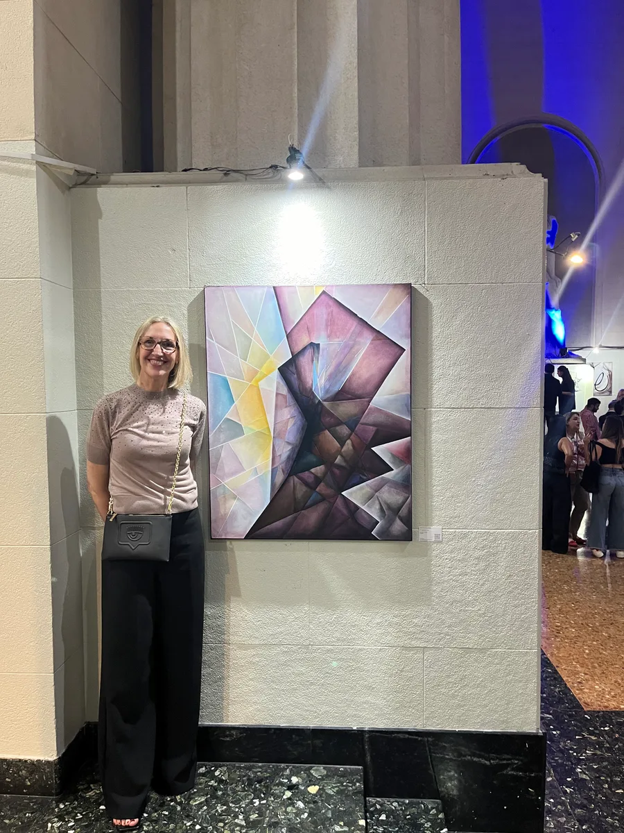 Marina Elizalde next to a painting in violet tones